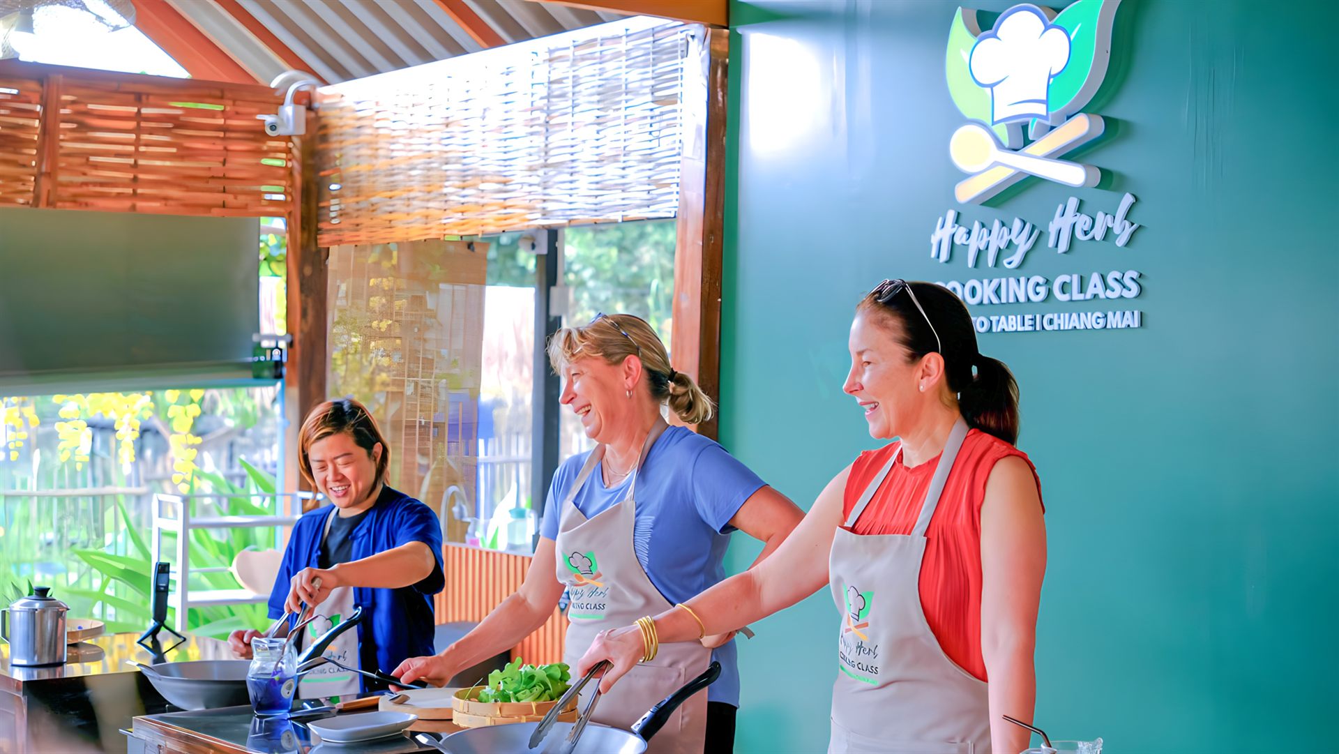 Guests cooking authentic Thai food together at Happy Herb Cooking Class in Chiang Mai