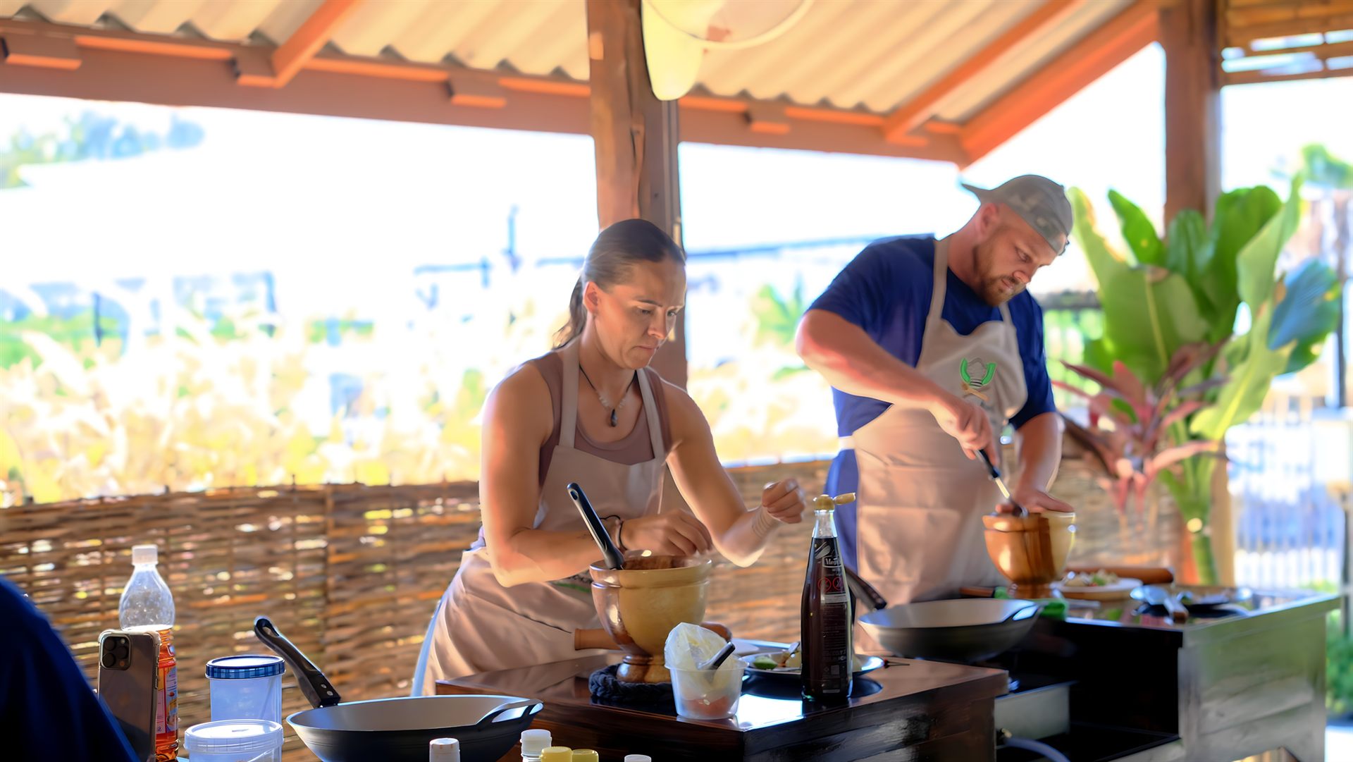 Guests preparing Thai dishes in the open-air Happy Herb cooking kitchen