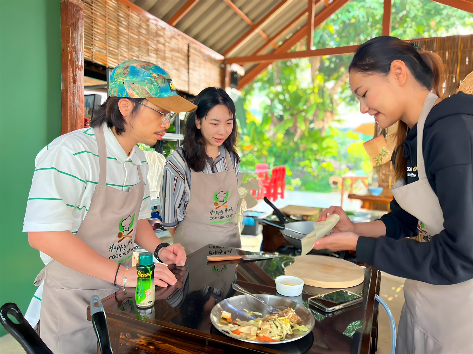 Travelers cooking together at the open-air kitchen of Happy Herb Cooking Class